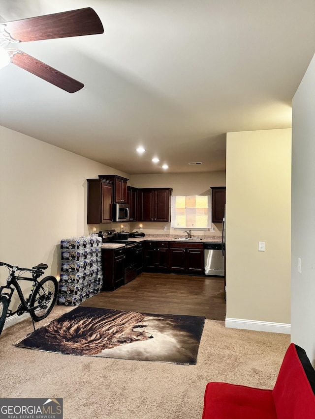 kitchen with carpet flooring, dark brown cabinetry, ceiling fan, sink, and stainless steel appliances