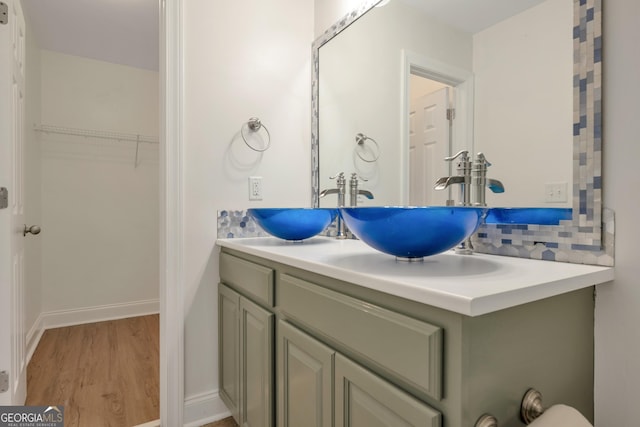 bathroom featuring decorative backsplash, vanity, and wood-type flooring