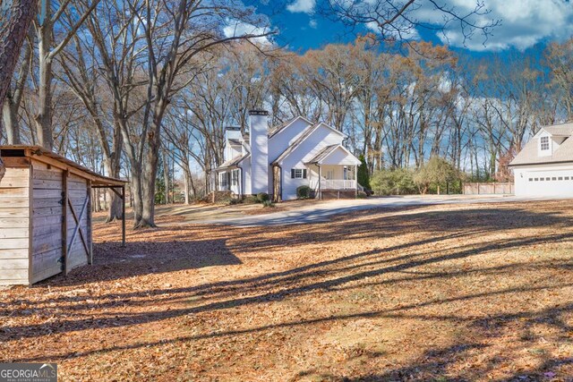 exterior space with a garage, covered porch, and an outbuilding