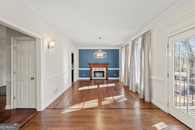 dining room with a premium fireplace, wood-type flooring, and ornamental molding