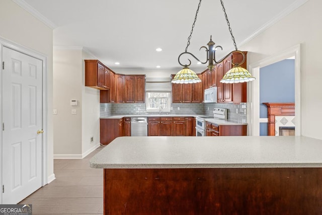 kitchen featuring kitchen peninsula, appliances with stainless steel finishes, backsplash, ornamental molding, and hanging light fixtures