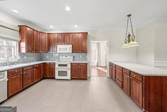 kitchen featuring pendant lighting, white appliances, backsplash, crown molding, and sink