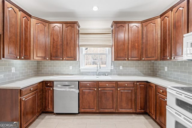 kitchen featuring backsplash, white appliances, and sink