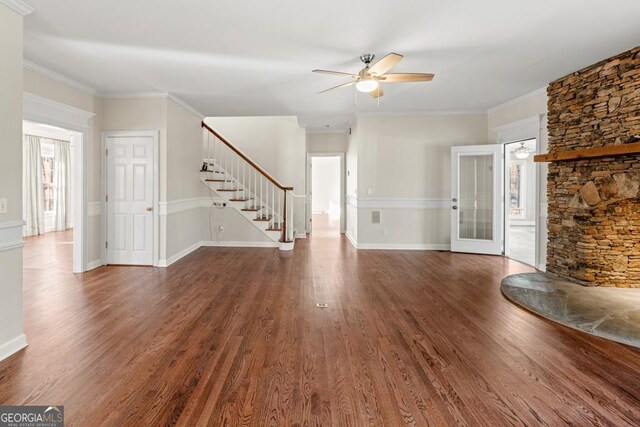 unfurnished living room with french doors, crown molding, dark hardwood / wood-style floors, ceiling fan, and a fireplace