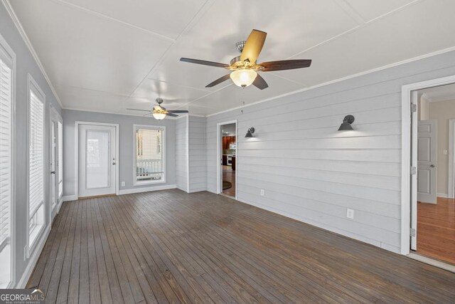 exterior space with dark hardwood / wood-style floors, ceiling fan, and wood walls