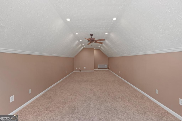 bonus room featuring ceiling fan, carpet floors, a textured ceiling, and a wall unit AC