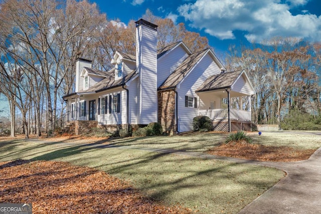 view of side of property with a yard and a porch