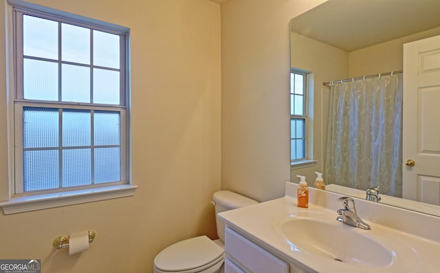 bathroom with vanity, toilet, and plenty of natural light