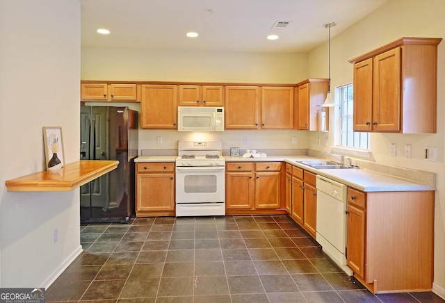 kitchen featuring white appliances, sink, and hanging light fixtures