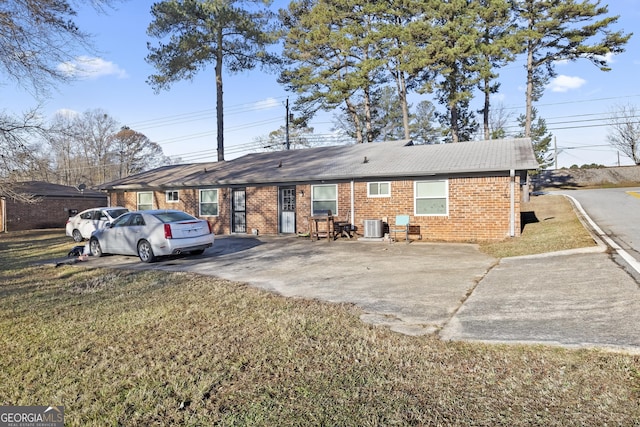 view of front of home with cooling unit and a front yard