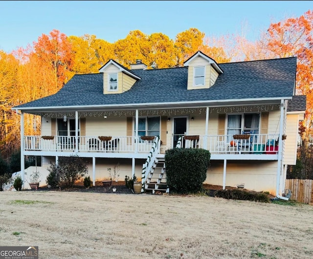 cape cod-style house with covered porch and a front yard