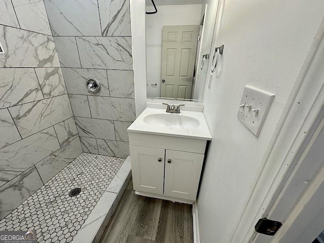 bathroom with a shower stall, vanity, and wood finished floors