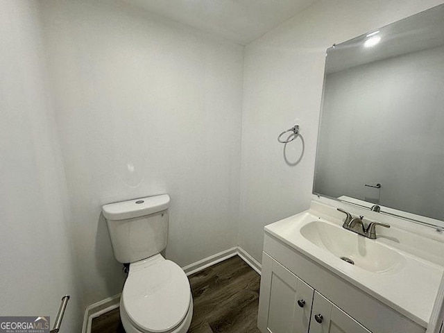 bathroom with toilet, vanity, and hardwood / wood-style flooring