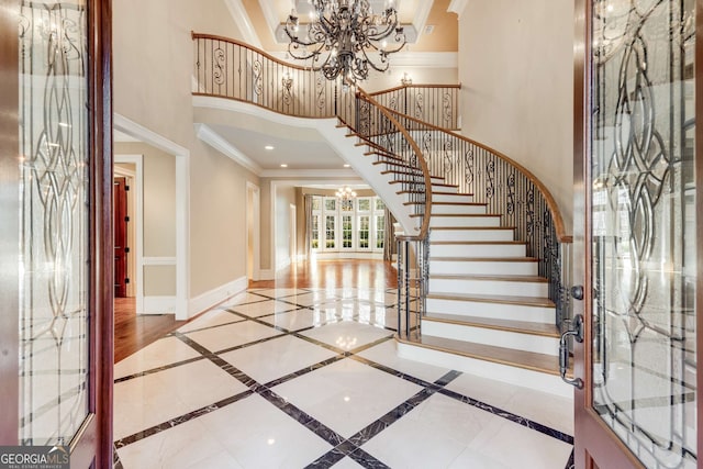 foyer featuring a chandelier and crown molding