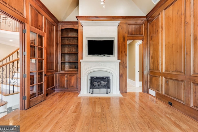 unfurnished living room with vaulted ceiling and light wood-type flooring