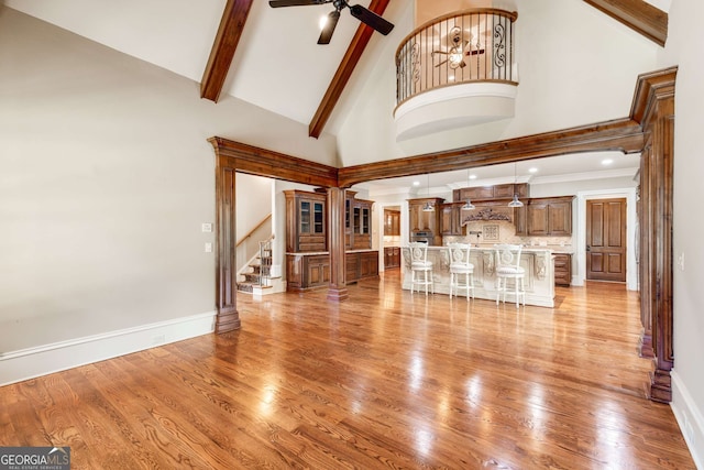 unfurnished living room with ceiling fan, high vaulted ceiling, and light hardwood / wood-style floors