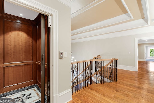 hallway with hardwood / wood-style floors, elevator, and ornamental molding