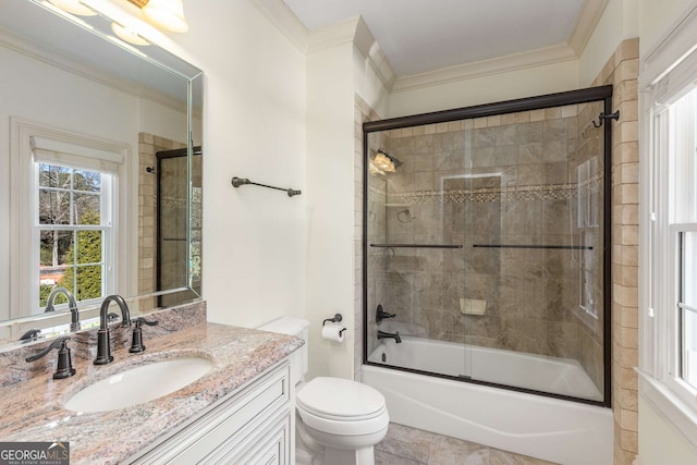 full bathroom featuring combined bath / shower with glass door, vanity, toilet, and crown molding