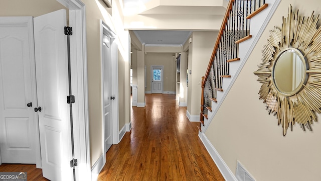 hallway featuring dark wood-type flooring and ornamental molding