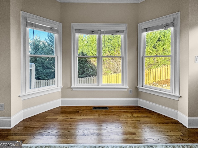 spare room with hardwood / wood-style floors and a healthy amount of sunlight