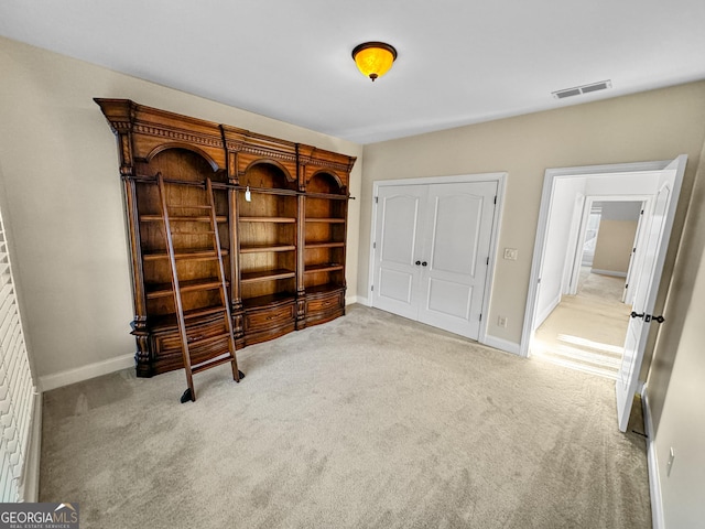 unfurnished bedroom with a closet and light carpet