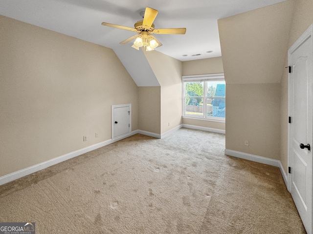 additional living space featuring light carpet, vaulted ceiling, and ceiling fan