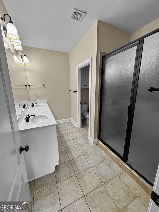 bathroom with vanity, toilet, an enclosed shower, and tile patterned flooring