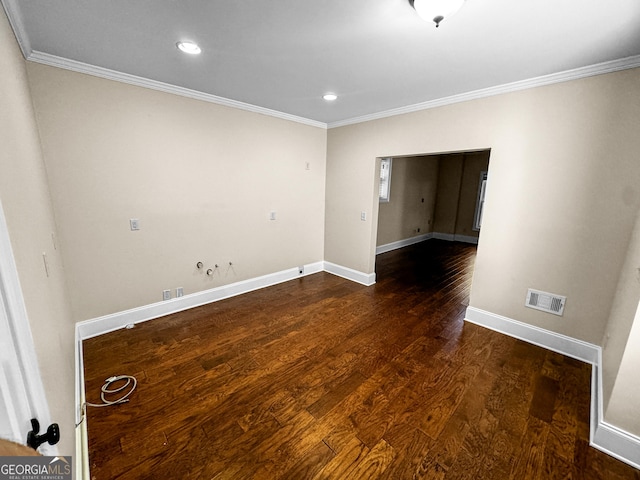 spare room with ornamental molding and dark hardwood / wood-style flooring