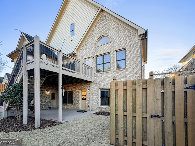 rear view of property with a wooden deck and a patio area