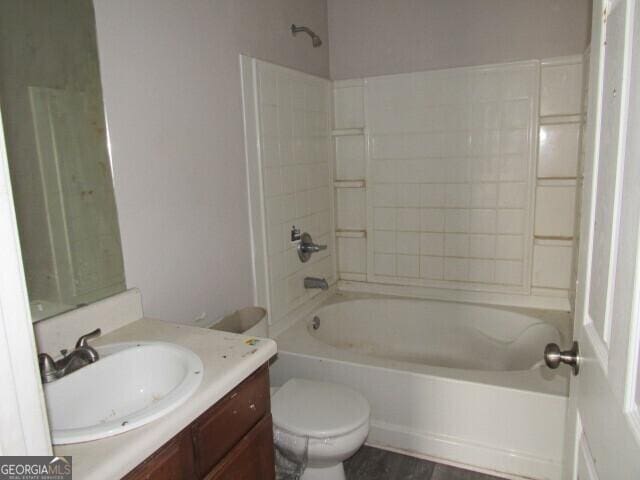 full bathroom with hardwood / wood-style flooring, shower / washtub combination, vanity, and toilet