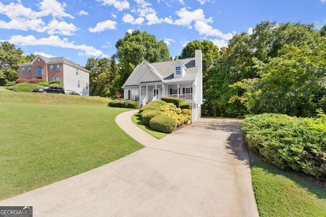 new england style home with covered porch and a front lawn