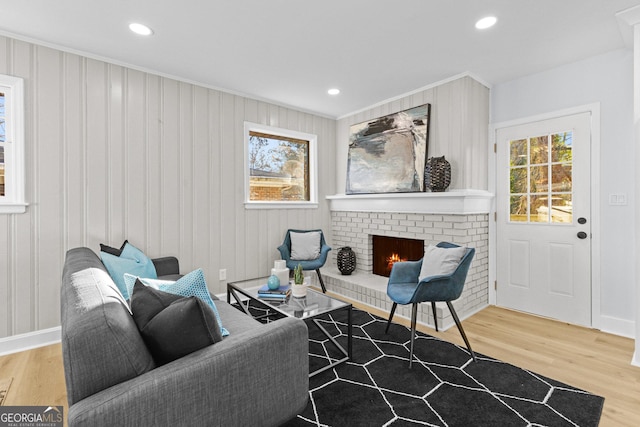 sitting room featuring hardwood / wood-style floors, a brick fireplace, and ornamental molding