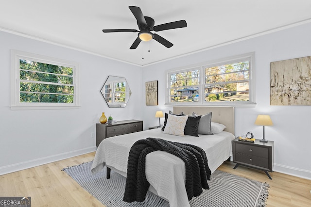 bedroom featuring light wood-type flooring, ceiling fan, and crown molding