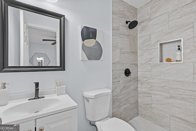 bathroom featuring tiled shower, vanity, and toilet