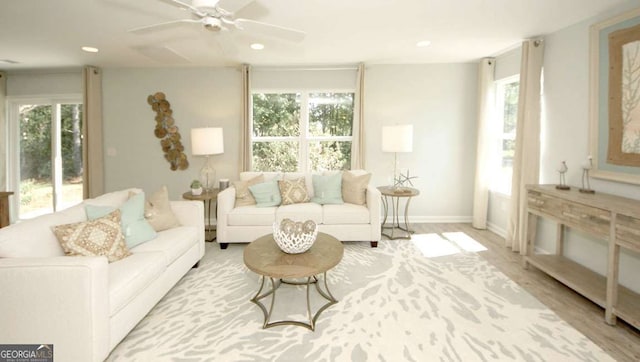 living room featuring light hardwood / wood-style flooring and ceiling fan