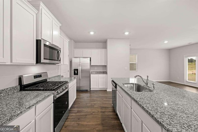 kitchen with white cabinetry, sink, light stone counters, dark hardwood / wood-style flooring, and appliances with stainless steel finishes