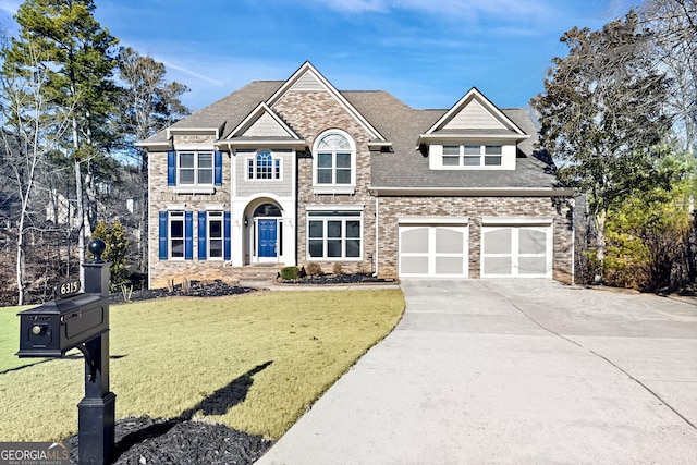 craftsman house featuring driveway, a garage, a front lawn, and roof with shingles