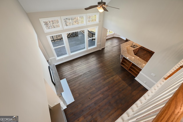 living area with dark wood finished floors, baseboards, and ceiling fan