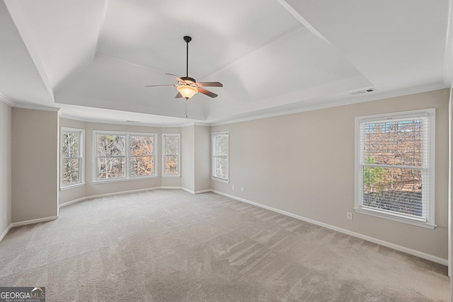 spare room with carpet, a raised ceiling, visible vents, ceiling fan, and baseboards