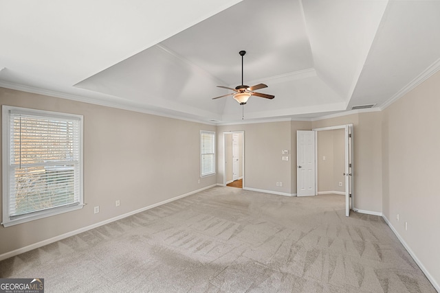 unfurnished room with a tray ceiling, a healthy amount of sunlight, visible vents, and baseboards