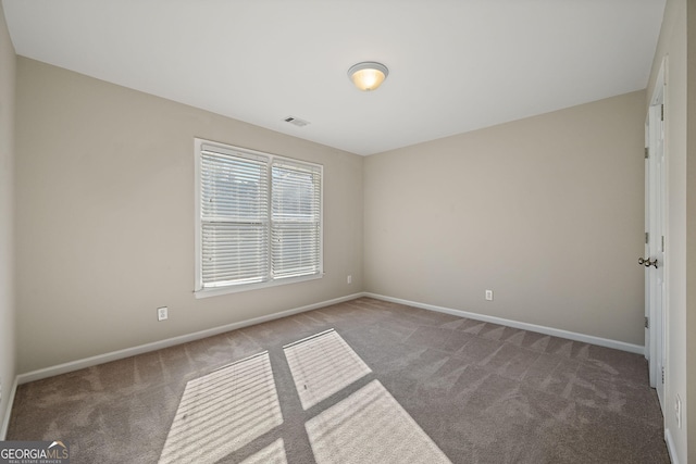 empty room featuring carpet, visible vents, and baseboards