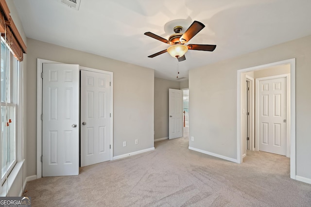 unfurnished bedroom featuring carpet floors, a closet, visible vents, ceiling fan, and baseboards