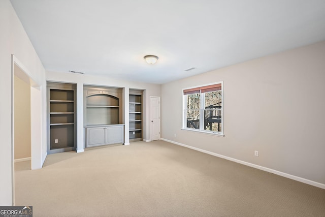 unfurnished bedroom with light carpet, visible vents, and baseboards