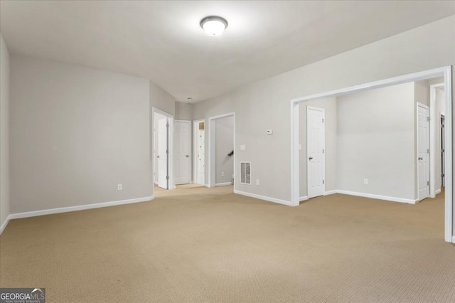 unfurnished bedroom featuring light carpet, visible vents, and baseboards