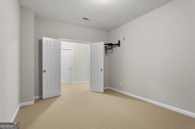 unfurnished bedroom with carpet, visible vents, and baseboards