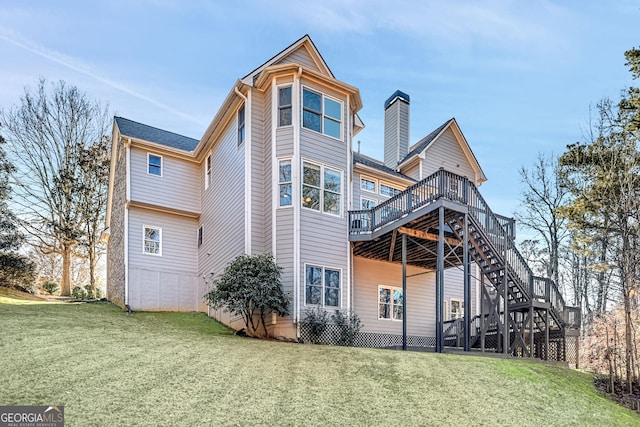 back of property with stairway, a deck, and a lawn