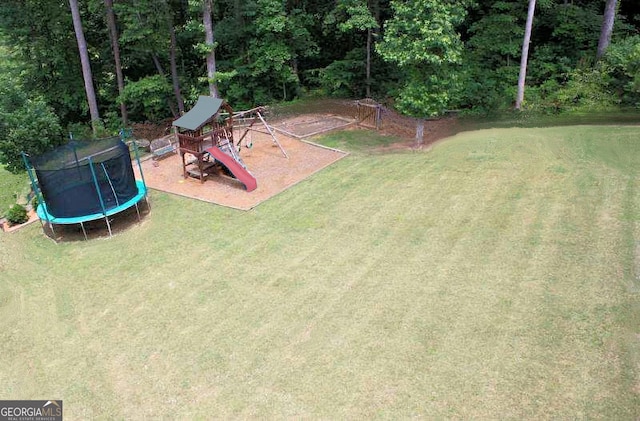 view of yard featuring a trampoline and a playground