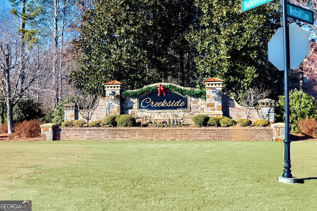 community / neighborhood sign featuring a yard