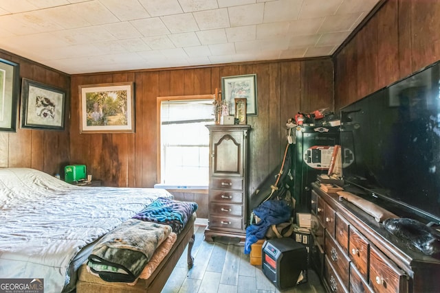 bedroom featuring light wood-type flooring and wooden walls