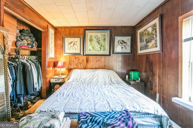 bedroom featuring a closet and wood walls